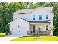 Two-story house with white siding, stone accents, and a two-car garage at 134 Henley St, Canton, GA 30114