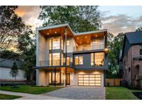 Modern two-story house with a glass garage door and stone driveway at 1281 Avalon Ne Pl, Atlanta, GA 30306