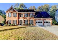 Brick two-story house with a two-car garage and manicured lawn at 3034 Brookgreen Trl, Lawrenceville, GA 30043