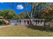 Brick ranch house with a red door and attached garage at 929 Pine Roc Dr, Stone Mountain, GA 30083