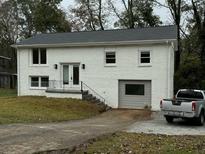 Newly painted white ranch house with attached garage at 6848 Maddox Rd, Morrow, GA 30260