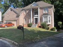 Two-story brick home with attached garage and landscaped lawn at 533 Riverbirch Trce, Stone Mountain, GA 30087