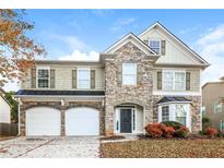 Two-story house with stone and shingle exterior, two-car garage at 4815 Plainsman Cir, Cumming, GA 30028