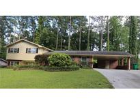 Ranch style home with brick facade, carport, and well-maintained lawn at 2501 Henderson Mill Ne Rd, Atlanta, GA 30345