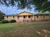 Brick ranch home with yellow accents and carport at 25 Bryans Dr, Mcdonough, GA 30252