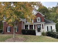 Brick two-story house with a front porch and landscaping; American flag displayed at 3559 Gus Way, Powder Springs, GA 30127