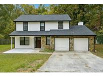 Two-story house with a two-car garage and stone accents at 5271 Kelleys Mill Cir, Stone Mountain, GA 30088