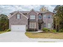Two-story house with brick facade and a large driveway at 4203 Shandi Cv, Hoschton, GA 30548
