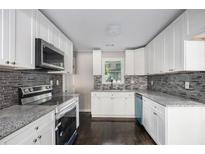Modern kitchen with white cabinets, granite counters, and stainless steel appliances at 3060 Washington Rd, Atlanta, GA 30344