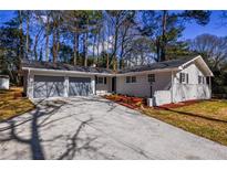 Newly renovated ranch home with a two-car garage and landscaped front yard at 1328 White Oak Se St, Conyers, GA 30013