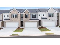 Three townhouses with attached garages and landscaping at 2718 Honey Locust Ct, Loganville, GA 30052