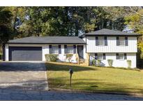 Charming ranch home with gray garage door and white exterior at 7543 Palmetto Way, Riverdale, GA 30274