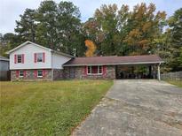 Brick ranch house with red shutters and carport at 7437 Grayson Dr, Riverdale, GA 30296