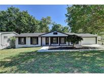 Charming ranch house with white brick exterior, black trim, and a manicured lawn at 1365 Renee Dr, Decatur, GA 30035