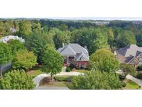 Brick home with circular driveway, surrounded by lush green trees at 2703 Thurleston Ln, Duluth, GA 30097