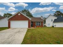 Brick ranch home with attached garage and landscaped lawn at 1712 Graystone Dr, Hampton, GA 30228