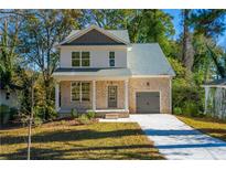 Two-story brick home with gray accents, front porch, and driveway at 2126 Seavey Dr, Decatur, GA 30032