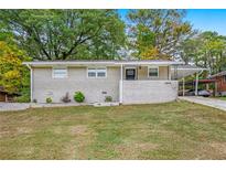 Ranch style home with carport and landscaped lawn at 2910 Delowe Dr, Atlanta, GA 30344