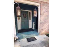 Inviting front porch with lanterns and a teal door at 6340 Koweta Rd, Fairburn, GA 30213