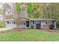 Brick ranch home with a landscaped yard and driveway at 7047 Carolyn Cir, Lithia Springs, GA 30122