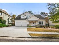 Two-story house with beige siding, three-car garage, and a well-manicured lawn at 436 Gold Xing, Canton, GA 30114