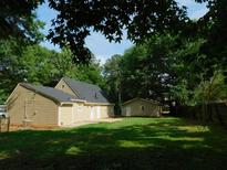 Spacious backyard with a detached garage and mature trees at 99 Libby Ln, Jonesboro, GA 30238