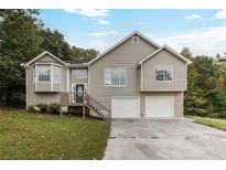 Two-story house with a double garage and landscaped yard at 2791 Willow Tree Overlook, Douglasville, GA 30315