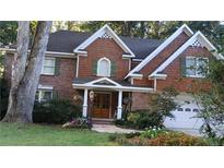 Two-story home with brick and wood siding, and a covered porch at 2565 Binghamton Dr, Atlanta, GA 30360