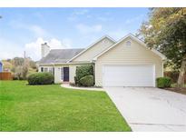 Beige house with a white garage door and green lawn at 4112 Meadowlark Ct, Powder Springs, GA 30127