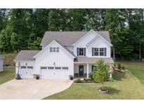 Two story home with white siding, three car garage and landscaped yard at 197 Stafford Ln, Villa Rica, GA 30180
