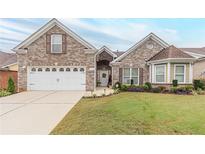 Brick house with a two-car garage and well-maintained lawn at 1152 Simonton Glen Way, Lawrenceville, GA 30045