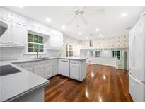 Bright kitchen with white cabinets, granite countertops, and hardwood floors at 1010 Martin Ridge Rd, Roswell, GA 30076