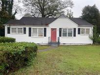 White house with red door and black shutters at 6848 Church St, Lithonia, GA 30058