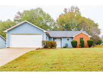 Ranch home with attached garage and landscaped yard at 1121 Whisper Wind Dr, Mcdonough, GA 30253