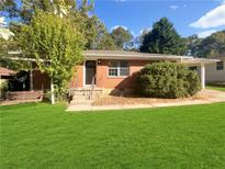 Brick ranch home with a well-manicured lawn at 828 Pinevalley Dr, Forest Park, GA 30297