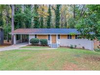 Brick ranch home with carport, needing renovations, set on a grassy lot at 2648 Cavalier Dr, Decatur, GA 30034