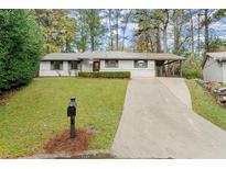 Charming Ranch home with a carport and well-manicured lawn at 6107 Phillip Ln, Lithonia, GA 30058