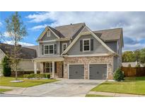 Two-story house with gray siding, brick accents, and a two-car garage at 3233 Harmony Hill Trce, Kennesaw, GA 30144