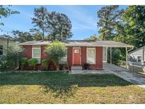 Charming brick ranch home with a red door and landscaped yard at 2648 Santa Monica Nw Dr, Atlanta, GA 30318