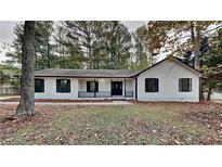 Newly renovated home features white siding, black window trim, and a landscaped yard at 245 Southmoor Cir, Stockbridge, GA 30281