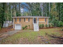 Ranch style home with a tan exterior and a white front door at 245 E Simon Nw Ter, Atlanta, GA 30318