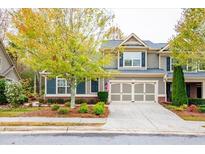 Two-story home with gray siding, three-car garage, and landscaping at 1595 Water Vista Ct # 4301, Cumming, GA 30041