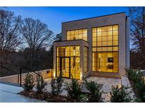 Modern home exterior with large windows and brick facade at twilight at 247 Huntington Ne Rd, Atlanta, GA 30309
