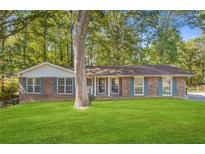 Brick ranch house with green lawn at 141 Denna Dr, Alpharetta, GA 30009