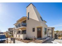 Modern light beige three-story home with dark wood front door and balcony at 1180 Lupo Loop, Chattahoochee Hills, GA 30268