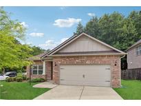 Brick ranch home with two-car garage and landscaped lawn at 3353 Newtons Crest Cir, Snellville, GA 30078