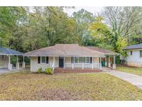Brick ranch home with a covered porch and a well-manicured lawn at 1788 Danrich Dr, Decatur, GA 30032
