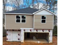 Two-story house with beige vinyl siding, a two-car garage, and a white front door at 100 Deer Xing, Temple, GA 30179