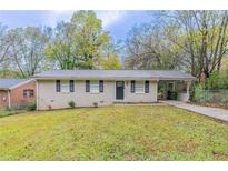 Brick ranch house with a driveway and landscaped yard at 3851 Bonnie Se Ln, Atlanta, GA 30354