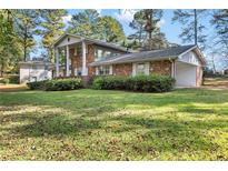 Brick ranch home with attached garage and spacious lawn at 1318 Zachary Way, Norcross, GA 30093